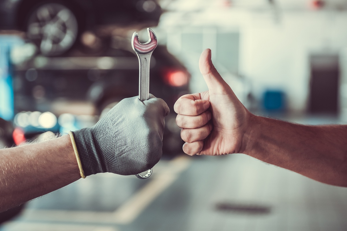 Car mechanic and customer fist bump
