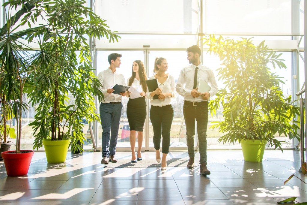 happy employees inside building with plants