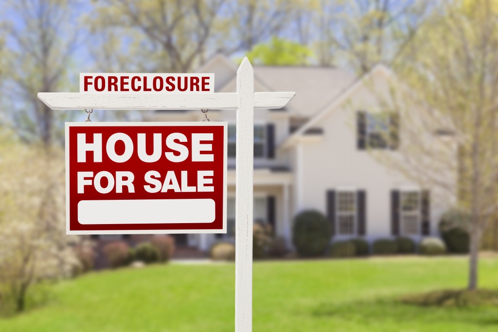 Red Foreclosure Home For Sale Real Estate Sign in Front of House
