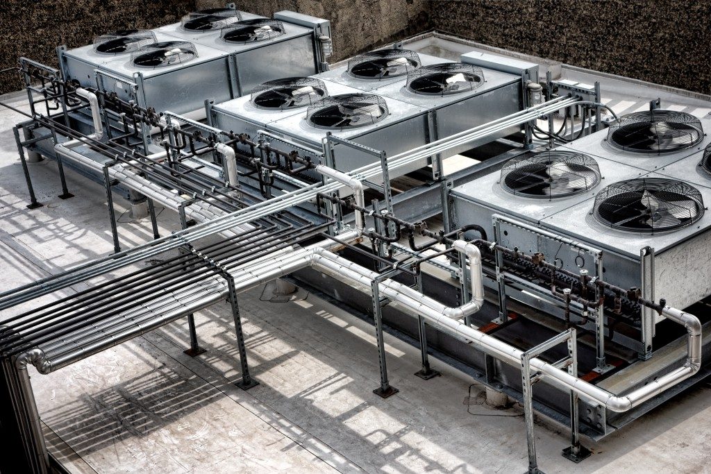Commercial cooling HVAC air conditioner condenser fan units battery set on large commercial building rooftop for climate control and refrigeration temperature AC conditioning system