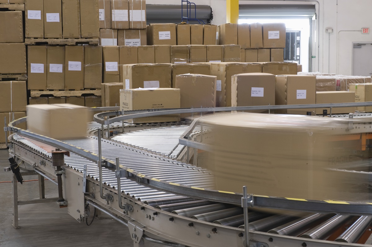 Closeup of a conveyor belt distributing boxes in a warehouse